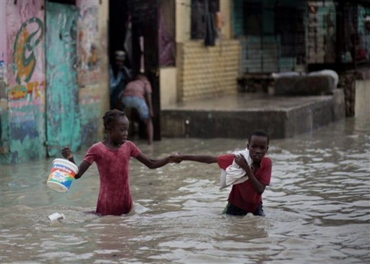 Children cross a flooded street after the passing of Hurricane Tomas in Port-au-Prince, Haiti, on Nov. 6.